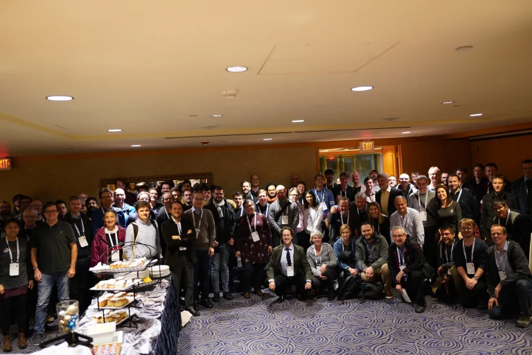 Group photo of a lot of people in a conference room smiling for a photo