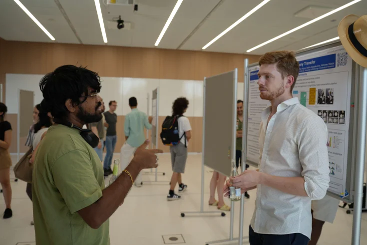 Two men talking at the poster session at ELLIS Unit Freiburg
