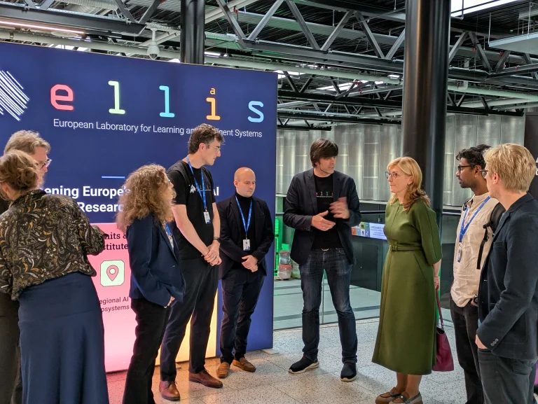 Matthias Bethge, Arnout Devos and Antoine Bosselut speak with European Commissioner Ekaterina Zaharieva at the ELLIS Booth at AIS25 in Copenhagen