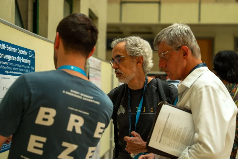 Mario Figueiredo and Arlindo Oliveira looking at a poster at the ELLIS Doctoral Symposium 2026 in Lisbon