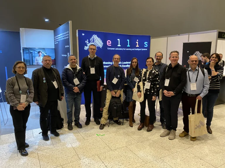 Tatiana Tommasi, Petri Myllymäki, Serge Belongie, Samuel Kaski, Nicolò Cesa-Bianchi, Celia Sanchez, Laura Ruotsalainen, Gustau Camps-Valls, Cees Snoek, Joachim Denzler, Florence d'Alché-Buc standing in front of the ELLIS booth at EurIPS