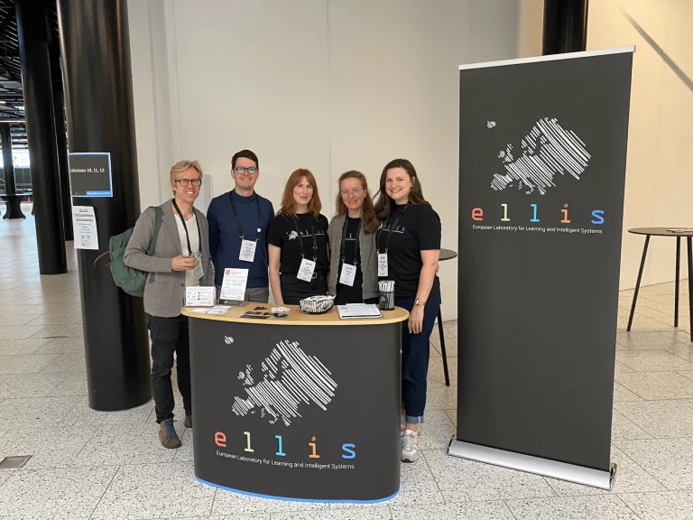 Soeren Hauberg, Vincent Fortuin, Lena Schadock, Daniela Beyer, Christine Funke standing behind the ELLIS island and next to an ELLIS roll up