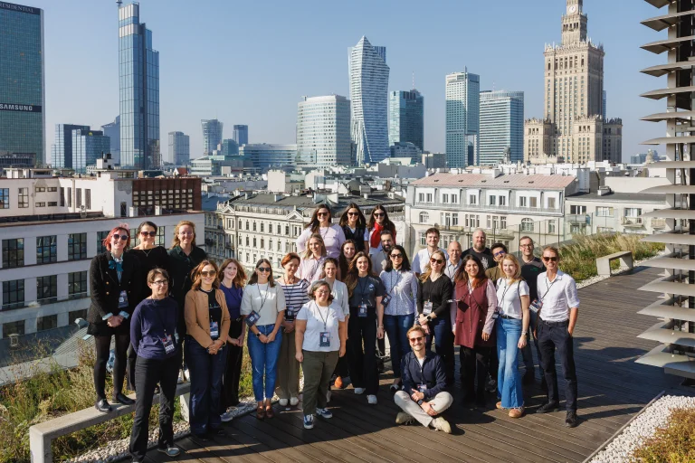 Group of ELLIS Coordinators and Staff standing on a rooftop in front of the Warsaw skyline