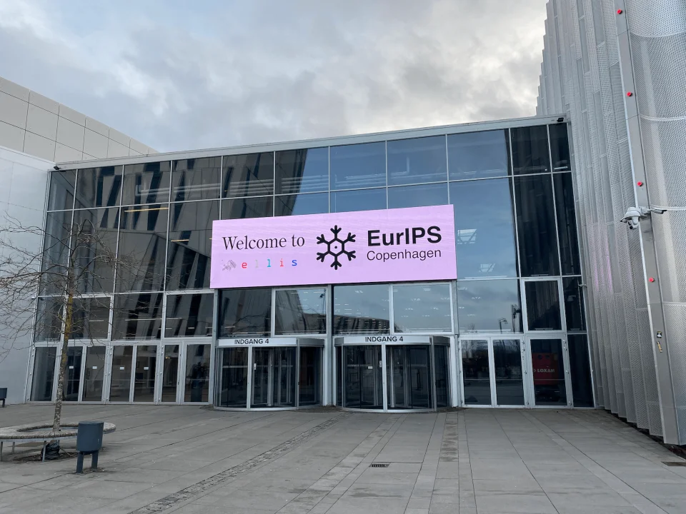 Large sign on the side of a building that says Welcome to ELLIS, EurIPS Copenhagen